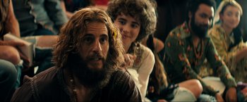 Movie still from “Jesus Revolution” (2023), directed by Brent McCorkle – A man and a woman are sitting next to each other; Close Up shot, Over the shoulder angle