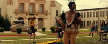 Movie still from “Jesus Revolution” (2023), directed by Brent McCorkle – A man with a microphone standing in front of people; Medium shot, Low angle