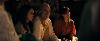 Movie still from “Jesus Revolution” (2023), directed by Brent McCorkle – A man and two women sitting next to each other; Medium shot, Over the shoulder angle