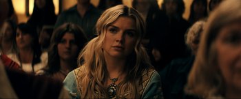 Movie still from “Jesus Revolution” (2023), directed by Brent McCorkle – A woman with long blonde hair wearing a necklace; Close Up shot, Over the shoulder angle