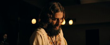 Movie still from “Jesus Revolution” (2023), directed by Brent McCorkle – A man with long hair and a beard is looking down; Close Up shot, Low angle