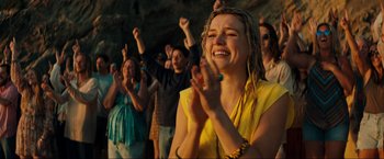 Movie still from “Jesus Revolution” (2023), directed by Brent McCorkle – A woman clapping her hands in front of a group of people; Close Up shot, Low angle