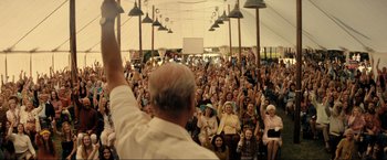 Movie still from “Jesus Revolution” (2023), directed by Brent McCorkle – A crowd of people sitting and standing in front of a tent; Extreme Wide shot, High angle