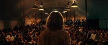 Movie still from “Jesus Revolution” (2023), directed by Brent McCorkle – A crowd of people sitting in front of an audience; Wide shot, Over the shoulder angle
