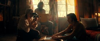 Movie still from “Jesus Revolution” (2023), directed by Brent McCorkle – A group of people sitting in a living room; Medium shot, Low angle