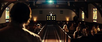Movie still from “Jesus Revolution” (2023), directed by Brent McCorkle – People sitting in pews in an old style church; Extreme Wide shot, Low angle