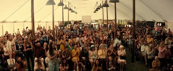Movie still from “Jesus Revolution” (2023), directed by Brent McCorkle – A large group of people sitting and standing in front of an audience; Wide shot, High angle