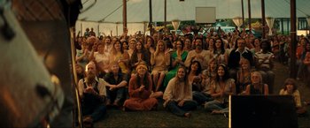 Movie still from “Jesus Revolution” (2023), directed by Brent McCorkle – A large group of people sitting on the ground; Wide shot, High angle