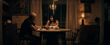 Movie still from “Jesus Revolution” (2023), directed by Brent McCorkle – Two people sitting at a table with a plate of food in front of them; Medium shot, Over the shoulder angle