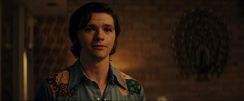 Movie still from “Jesus Revolution” (2023), directed by Brent McCorkle – A man with long brown hair wearing a blue shirt; Close Up shot, Over the shoulder angle