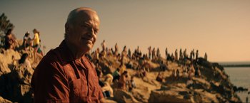 Movie still from “Jesus Revolution” (2023), directed by Brent McCorkle – A man standing in front of a crowd of people on a beach; Close Up shot, Over the shoulder angle