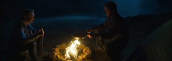 Movie still from “Joe Bell” (2020), directed by Reinaldo Marcus Green – A man sitting on the ground cooking over a fire; Wide shot, High angle
