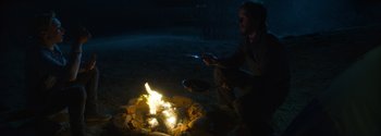 Movie still from “Joe Bell” (2020), directed by Reinaldo Marcus Green – A man sitting in front of a fire at night; Wide shot, High angle