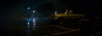 Movie still from “Joe Bell” (2020), directed by Reinaldo Marcus Green – A yellow truck parked in a parking lot at night; Extreme Wide shot, High angle