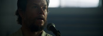 Movie still from “Joe Bell” (2020), directed by Reinaldo Marcus Green – A person speaking into a microphone; Close Up shot, Low angle