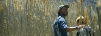 Movie still from “Joe Bell” (2020), directed by Reinaldo Marcus Green – A man standing in a field of tall grass; Medium shot, Low angle
