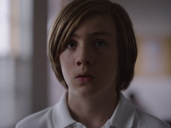 Movie still from “John and the Hole” (2021), directed by Pascual Sisto – A person wearing a white shirt; Close Up shot, Low angle