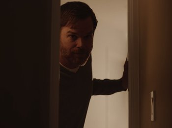 Movie still from “John and the Hole” (2021), directed by Pascual Sisto – A man standing in a doorway looking at the camera; Medium shot, Over the shoulder angle