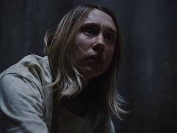 Movie still from “John and the Hole” (2021), directed by Pascual Sisto – A woman with blonde hair is staring at the camera; Close Up shot, Low angle