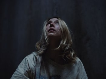 Movie still from “John and the Hole” (2021), directed by Pascual Sisto – A woman with long blonde hair looking upward; Close Up shot, Low angle