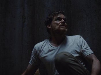 Movie still from “John and the Hole” (2021), directed by Pascual Sisto – A man sitting on the ground looking up; Medium shot, Low angle