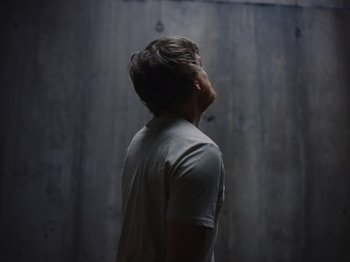 Movie still from “John and the Hole” (2021), directed by Pascual Sisto – A man standing in front of a wooden wall; Medium shot, Low angle