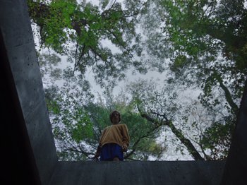 Movie still from “John and the Hole” (2021), directed by Pascual Sisto – A person standing on a ledge looking up at the sky; Extreme Wide shot, Low angle