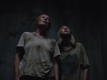 Movie still from “John and the Hole” (2021), directed by Pascual Sisto – Two women standing next to each other looking up at the sky; Medium shot, Low angle