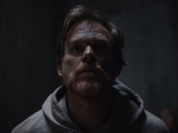 Movie still from “John and the Hole” (2021), directed by Pascual Sisto – A man with a goatee is looking at the camera; Close Up shot, Low angle
