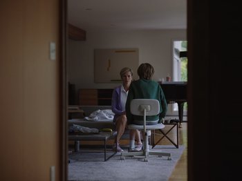 Movie still from “John and the Hole” (2021), directed by Pascual Sisto – Two people sitting in a room talking to each other; Wide shot, Over the shoulder angle