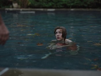 Movie still from “John and the Hole” (2021), directed by Pascual Sisto – A person in the water wearing a helmet; Close Up shot, High angle