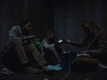 Movie still from “John and the Hole” (2021), directed by Pascual Sisto – A group of people sitting on the ground holding wii remotes; Wide shot, Low angle