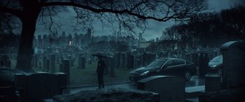 Movie still from “John Wick” (2014), directed by Chad Stahelski – A person holding an umbrella standing in a cemetery; Extreme Wide shot, High angle