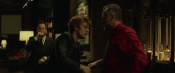 Movie still from “John Wick” (2014), directed by Chad Stahelski – Two men shake hands in a dark room; Medium shot, Over the shoulder angle