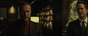 Movie still from “John Wick” (2014), directed by Chad Stahelski – A man wearing a suit and tie in a dark room; Close Up shot, Low angle