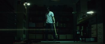 Movie still from “John Wick” (2014), directed by Chad Stahelski – A man holding a baseball bat while standing in a room; Wide shot, Low angle