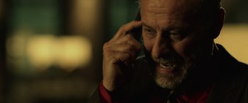 Movie still from “John Wick” (2014), directed by Chad Stahelski – An older man talking on a cell phone; Close Up shot, Low angle