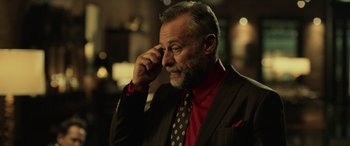 Movie still from “John Wick” (2014), directed by Chad Stahelski – An older man in a red shirt and a black jacket; Close Up shot, Over the shoulder angle