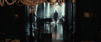 Movie still from “John Wick” (2014), directed by Chad Stahelski – A man walking down a hall way in a house; Wide shot, Low angle