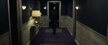 Movie still from “John Wick” (2014), directed by Chad Stahelski – A man walking down a hall way wearing a suit; Wide shot, Low angle