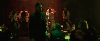 Movie still from “John Wick” (2014), directed by Chad Stahelski – A group of people sitting at a table in a room; Wide shot, Low angle