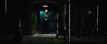 Movie still from “John Wick” (2014), directed by Chad Stahelski – Two men in suits are walking through a dark hallway; Wide shot, Low angle