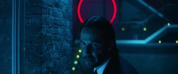 Movie still from “John Wick” (2014), directed by Chad Stahelski – A man in a suit standing next to a brick wall; Close Up shot, Low angle