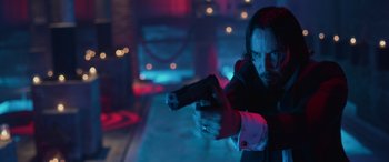 Movie still from “John Wick” (2014), directed by Chad Stahelski – A man holding a gun while standing in a dark room; Close Up shot, Low angle