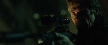 Movie still from “John Wick” (2014), directed by Chad Stahelski – A man with a rifle looking into the distance; Close Up shot, Low angle