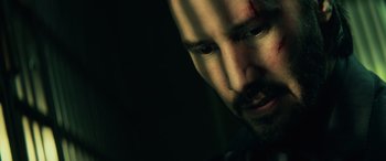 Movie still from “John Wick” (2014), directed by Chad Stahelski – A person with a scar on his face; Close Up shot, Overhead angle