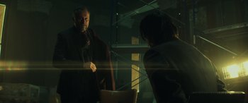 Movie still from “John Wick” (2014), directed by Chad Stahelski – A man and a woman are looking at each other in a dark room; Medium shot, Over the shoulder angle