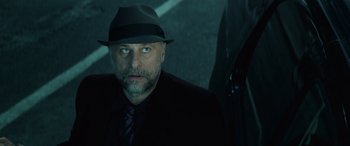 Movie still from “John Wick” (2014), directed by Chad Stahelski – A man in a suit and a hat is looking at the camera; Close Up shot, Low angle