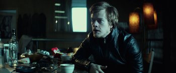 Movie still from “John Wick” (2014), directed by Chad Stahelski – A man sitting at a table with a cup of coffee; Close Up shot, Over the shoulder angle