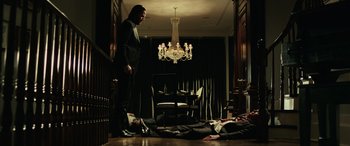 Movie still from “John Wick” (2014), directed by Chad Stahelski – A man standing next to a living room floor; Wide shot, Overhead angle